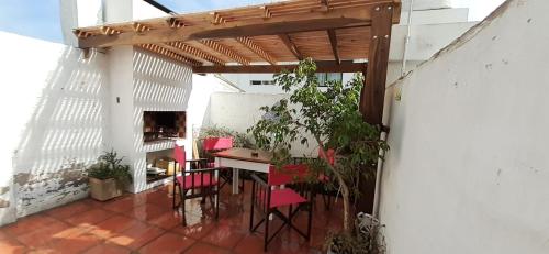 un patio con sillas rojas y una mesa en un edificio en Pepa en Tandil