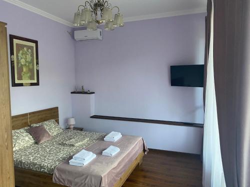 a small bedroom with a bed and a television at Grand Hotel in Mohyliv-Podilʼsʼkyy
