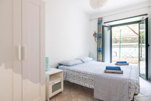 a bedroom with two beds and a balcony at Appartamento Pini in Cala Gonone