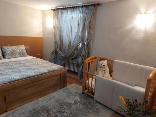 a bedroom with a bed and a crib with a teddy bear at LA CA' 'D PINET in Cuneo