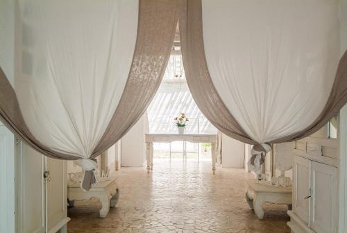 ギリ・トラワンガンにあるコーラル フローラ ヴィラ ビーチ フロントのカーテン2つと大きな窓が備わる客室です。