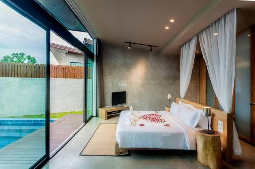 a bedroom with a bed and a swimming pool at Sea Two Pool Villa Resort Pattaya in Jomtien Beach