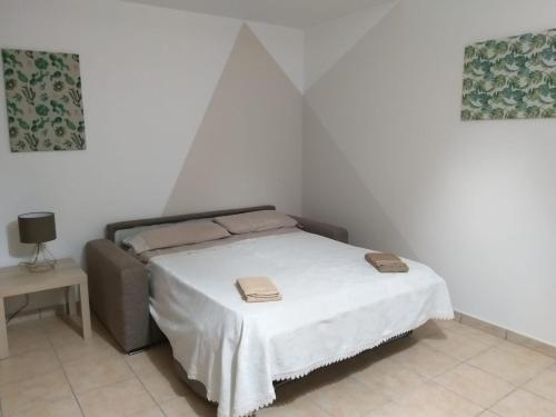 una piccola camera da letto con un letto con copriletto bianco di Dabliu House a Torrenova