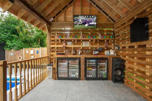 a wooden cabin with a tv on the wall at Luxurious oasis relax 32c pool, jacuzzi games bar in Deal
