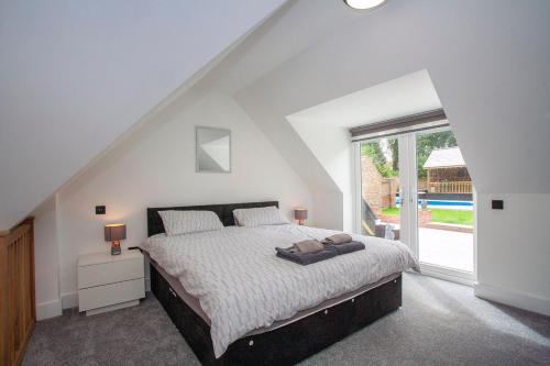 a bedroom with a bed and a large window at Luxurious oasis relax 32c pool, jacuzzi games bar in Deal