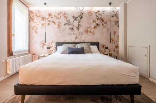 a bedroom with a large bed with a floral wall at Accademia Apartments R&R in Venice