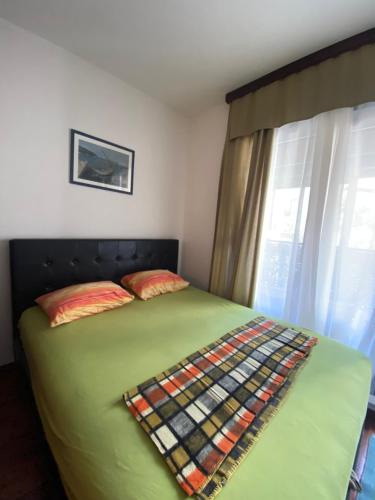 um quarto com uma cama verde e uma janela em Studio Apartment Nika Anđusa em Petrovac na Moru