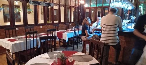 a man standing in a restaurant with people sitting at tables at hotel le Massilia in Belém