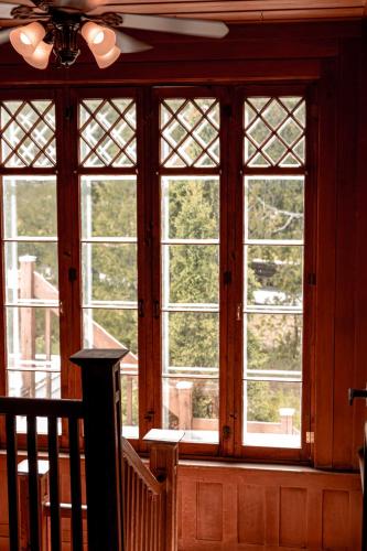 a room with four windows and a staircase in a house at Auberge Des 3 Canards in La Malbaie