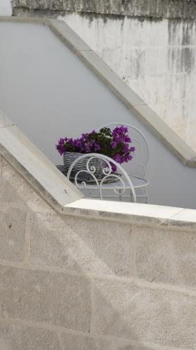 a planter with purple flowers sitting on a ledge at Sottacastieddu in Avetrana