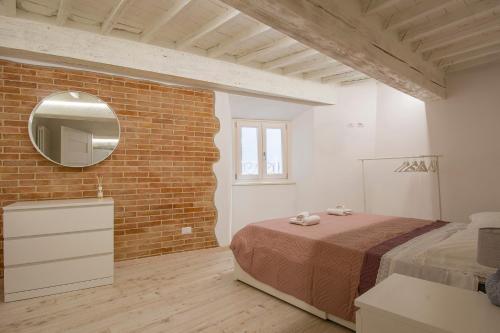 een slaapkamer met een bed en een bakstenen muur bij CASA ALICE - Elegant in the centre of the city in Siena