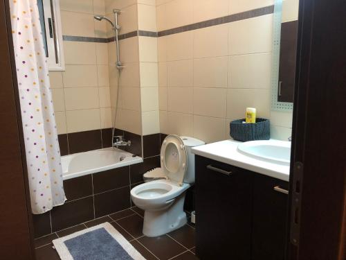 a bathroom with a toilet and a sink and a tub at Tranquil Country Condo in Larnaca