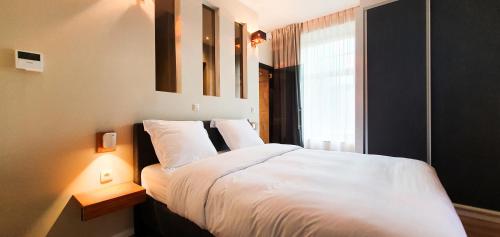 um quarto com uma cama branca e uma janela em Villa les érables Restaurant Linea em Spa