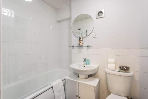 een badkamer met een wastafel, een toilet en een bad bij St Vincent Central Apartment in Glasgow