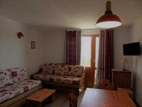 un salon avec un canapé et une table dans l'établissement travelski home classic - Résidence Carène, à Belle Plagne