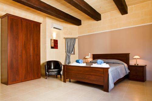 1 dormitorio con cama, escritorio y silla en Serkuzan, en Xagħra