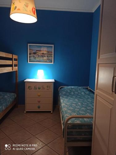 a bedroom with two twin beds and a blue wall at Casamare Baldassarri in Civitanova Marche