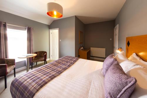 a bedroom with a bed and a table and a window at HK Rooms - Self Catering Rooms in Lowestoft