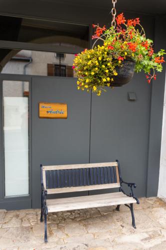 a bench with a flower pot hanging from a building at Maison Andree in Fresnes-sur-Apance