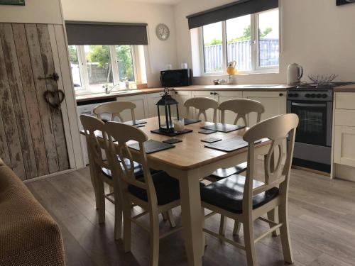 a kitchen with a wooden table and chairs in a room at Stone Cottage in Nazeing