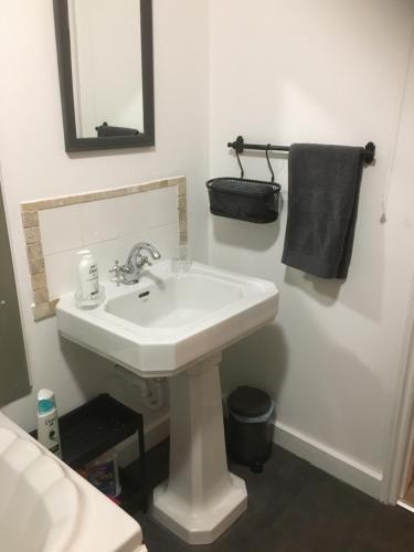 a white bathroom with a sink and a mirror at Stone Cottage in Nazeing