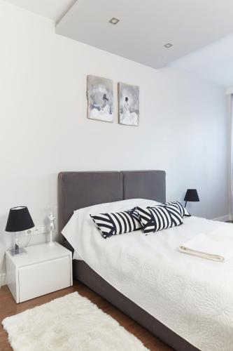 a bedroom with a bed with a black and white bedspread at Wronia Business Residence by BookingHost in Warsaw