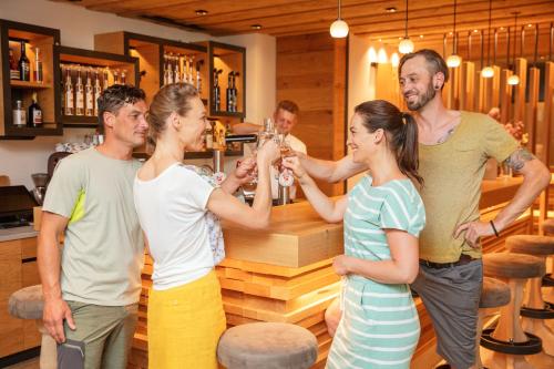 a group of people standing around a bar drinking champagne at Rosentalerhof Hotel & Appartements in Saalbach Hinterglemm