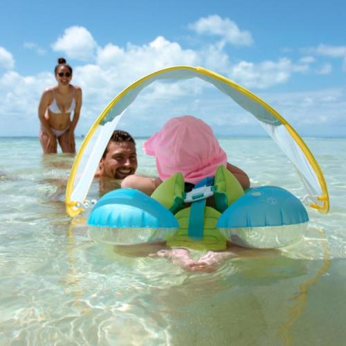 a man and a woman in the water at Pelican Beach Resort South Water Caye in Dangriga