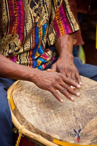 a person with their hands on a drum at Pelican Beach Resort South Water Caye in Dangriga