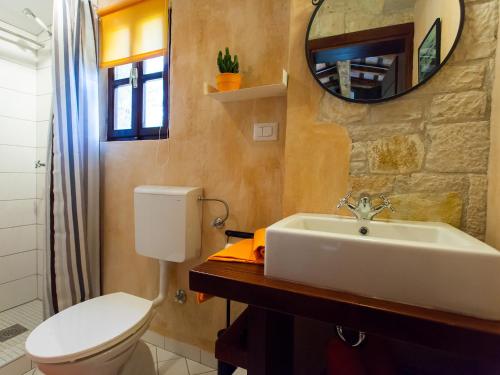 ein Badezimmer mit einem Waschbecken, einem WC und einem Spiegel in der Unterkunft Sun Garden Premium Apartments in Vrsar