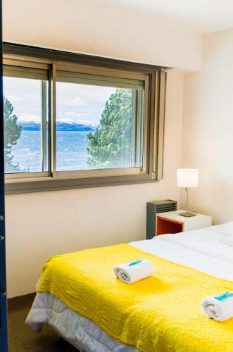a bedroom with two beds and a large window at Hormiga Negra Hostel & Café in San Carlos de Bariloche