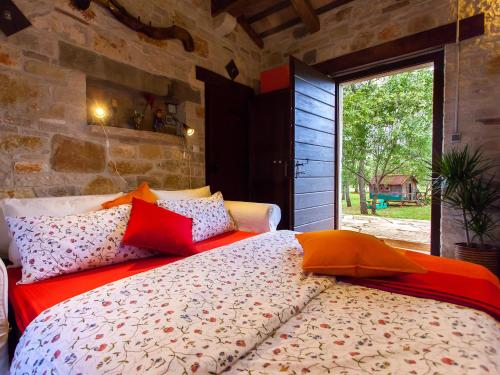 a bedroom with a large bed with red and orange pillows at Sun Garden Premium Apartments in Vrsar