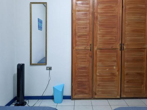 a wooden door in a room with a tv at Entire Comfy apartment for you, 5 min SJO Airport in Alajuela City
