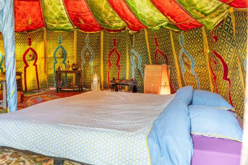 a bedroom with a bed in a tent at Au Bonheur Nomade in Livry