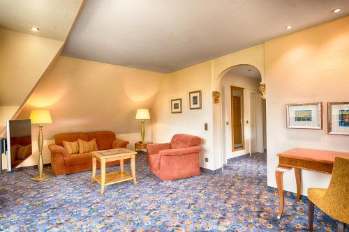 a living room with two chairs and a table at Hotel Thomahof in Hinterzarten
