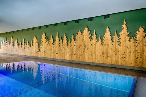 a mural of trees on a wall next to a pool at Hotel Thomahof in Hinterzarten