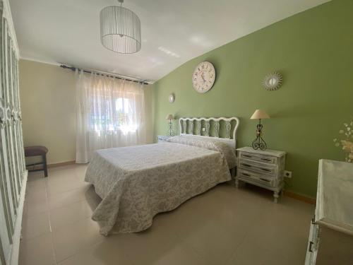 - une chambre avec un lit et une horloge murale dans l'établissement El Portal de la Sierra de Francia II, à San Miguel de Valero