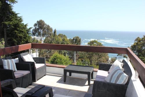 a balcony with chairs and a table and the ocean at Depto Maitencillo frente al Mar - Costamai in Maitencillo
