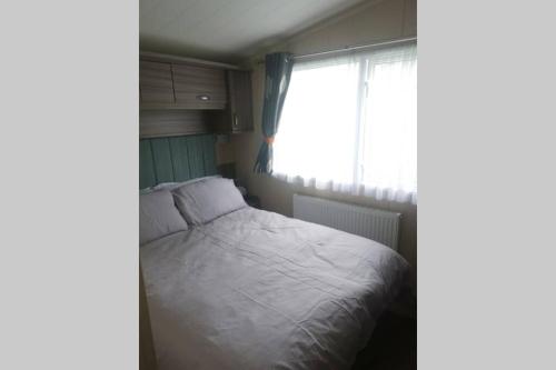 ein kleines Schlafzimmer mit einem Bett und einem Fenster in der Unterkunft Hoburne Devon Bay Static 3 Bed in Goodrington