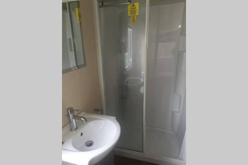 ein Bad mit einer Dusche und einem Waschbecken in der Unterkunft Hoburne Devon Bay Static 3 Bed in Goodrington