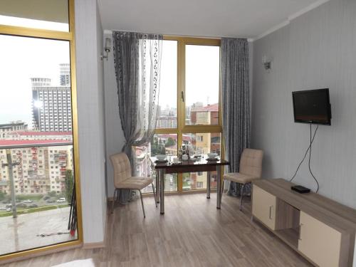 a living room with a table and a large window at Orbi Plaza Apartment in Batumi