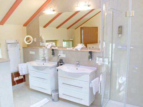 a bathroom with two sinks and a shower at Hotel Villa Monte Vino in Potsdam