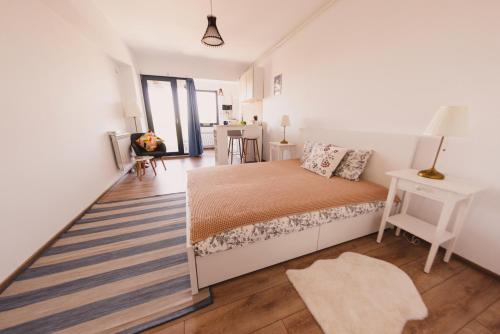 a white bedroom with a bed and a desk at Retro Studio by the SEA in Eforie Nord