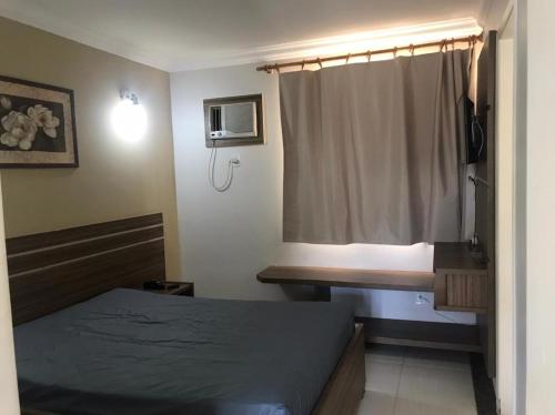 a bedroom with a bed and a desk and a window at DiRoma resort Caldas Novas in Caldas Novas