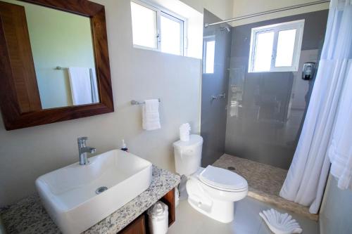 a bathroom with a sink and a toilet and a mirror at Viajero Sayulita Hostel in Sayulita