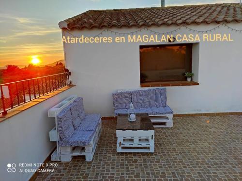 a building with two chairs and a table on a balcony at Alojamiento Rural MAGALAN in Pozo Alcón