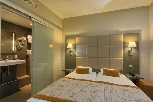 une chambre d'hôtel avec un lit et une salle de bain dans l'établissement Villa Margaux Opéra Montmartre, à Paris