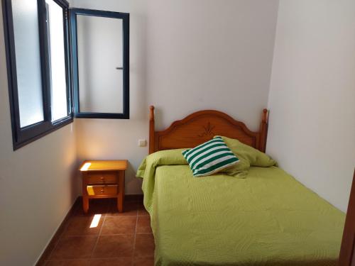 カレタ・デ・ファマラにあるCasa la Caletaのベッドルーム(緑のベッド1台、窓付)
