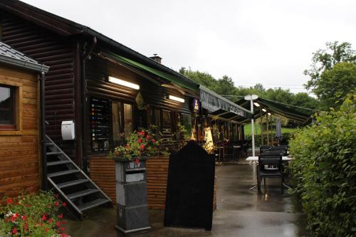 a building with a restaurant with tables and chairs at Chalet Ardennais 240 - La Boverie - Rendeux in Rendeux