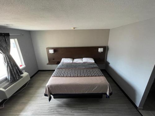 a bedroom with a bed and a large window at Ridge Motel in Breckenridge